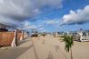 Rolling white waves crashing onto the wide golden sand shoreline of Elegushi Beach in Lekki, Lagos, featuring private beach lounges and palm trees.
